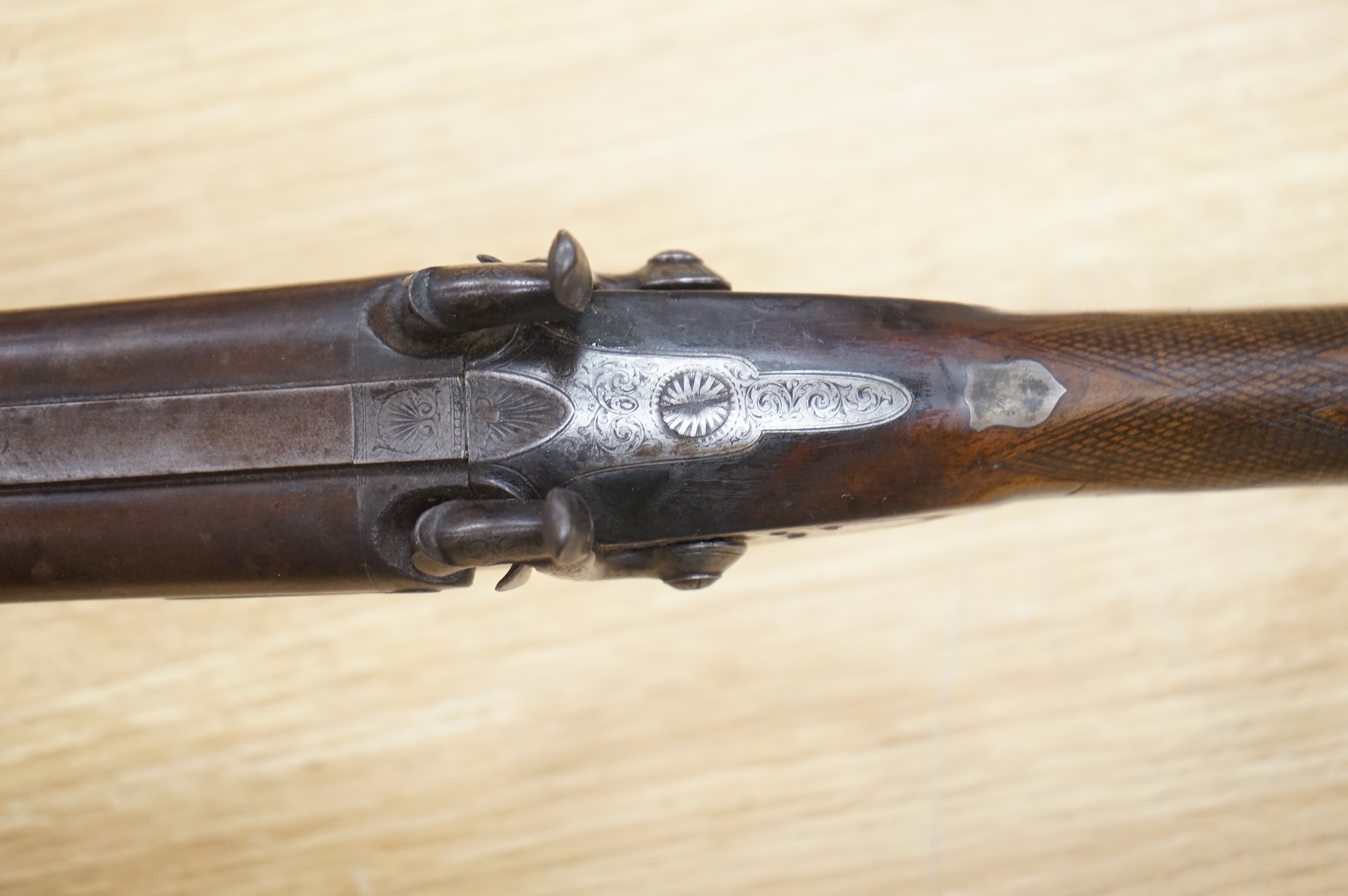 A double barrel 12 bore percussion sporting gun, signed Cocksedge, Hadleigh, with engraved locks and iron furniture, half stocked chequered grip with finger support in wood above guard